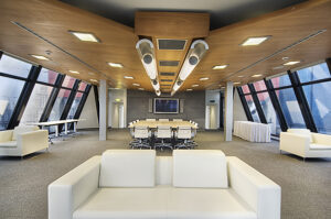 Modern meeting room with a large wooden conference table, ergonomic chairs, natural light, and minimalist decor in a commercial office.