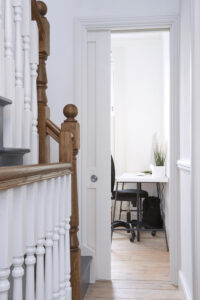 Interior stairs and pocket door with black and white color scheme, featuring natural wood accents for a modern, elegant look.