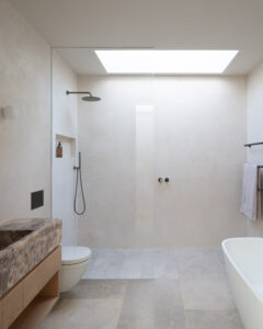 Bathroom with skylight providing natural light, modern design, and neutral tones.